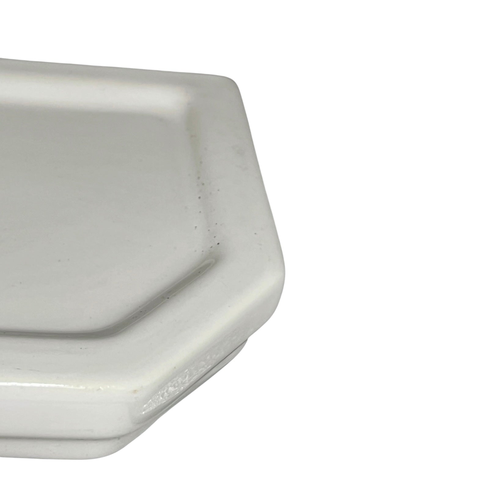 Corner of a white ceramic shelf on a white background