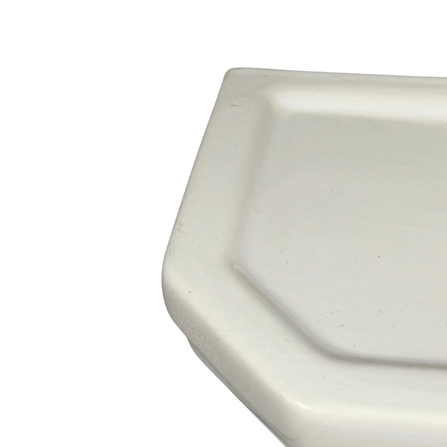 Close-up of a white ceramic shelf basin on a white background