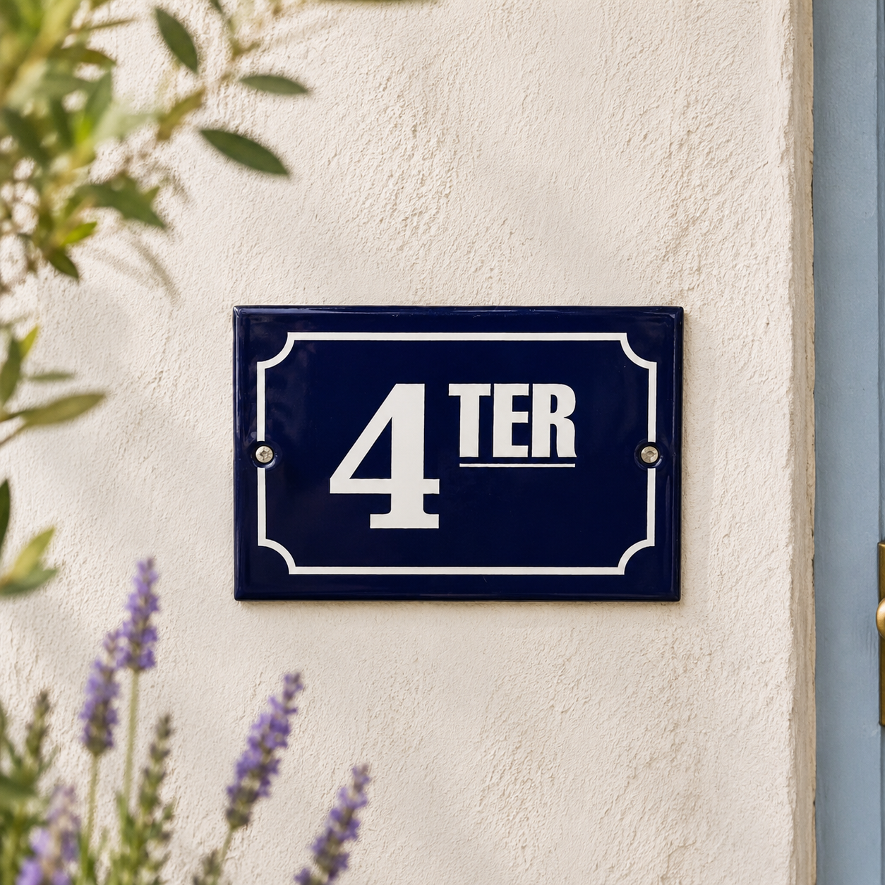 Navy blue house number sign with '4 TER' on a white wall, surrounded by greenery.