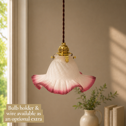 Pink glass pendant light with bulb holder and wire on a neutral background