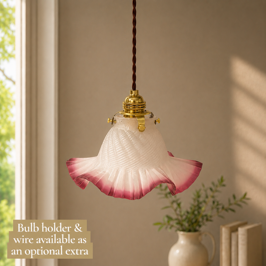 Pink glass pendant light with bulb holder and wire on a neutral background