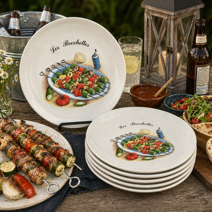 Set of ceramic plates with food illustrations on a wooden table with outdoor setting.