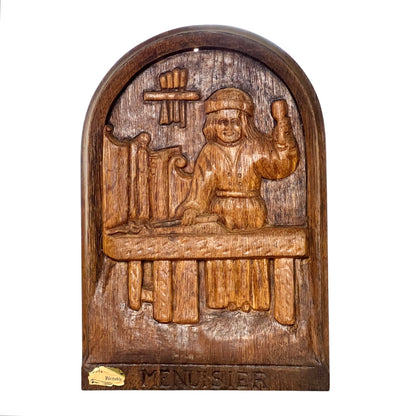 Wooden relief sculpture of a figure with a cross on a white background