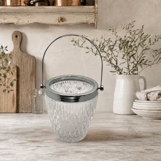 French vintage cut glass ice bucket with a chrome collar and handle on a counter top