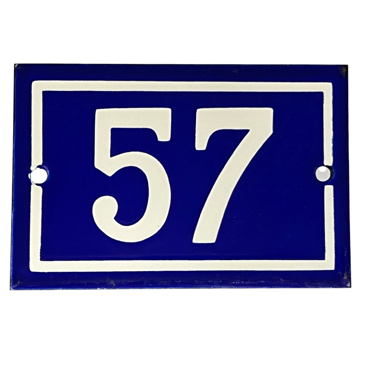 A rectangular blue and white house number plaque showing the number 57, photographed against a plain white background.