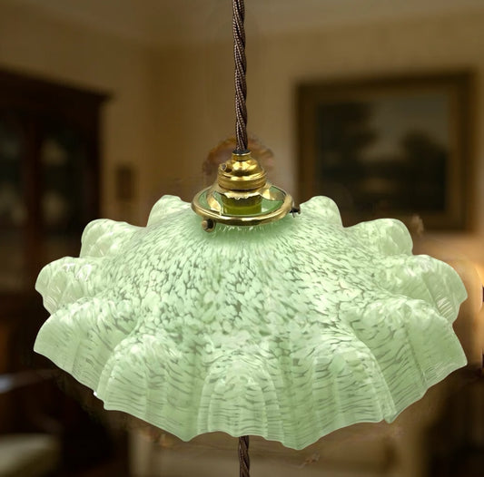 Vintage-style pendant light with textured green glass shade and brass fitting.