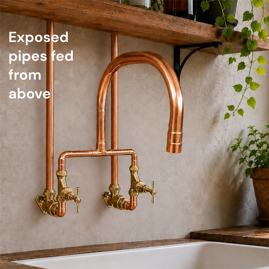 Copper kitchen faucet with exposed pipes mounted on a wall above a sink.