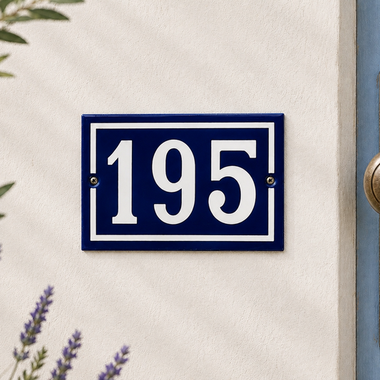 Blue house number plate with '195' on a white wall.