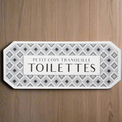 Decorative sign with French text on a wooden background