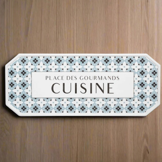 Decorative sign with patterned border and text on a wooden surface