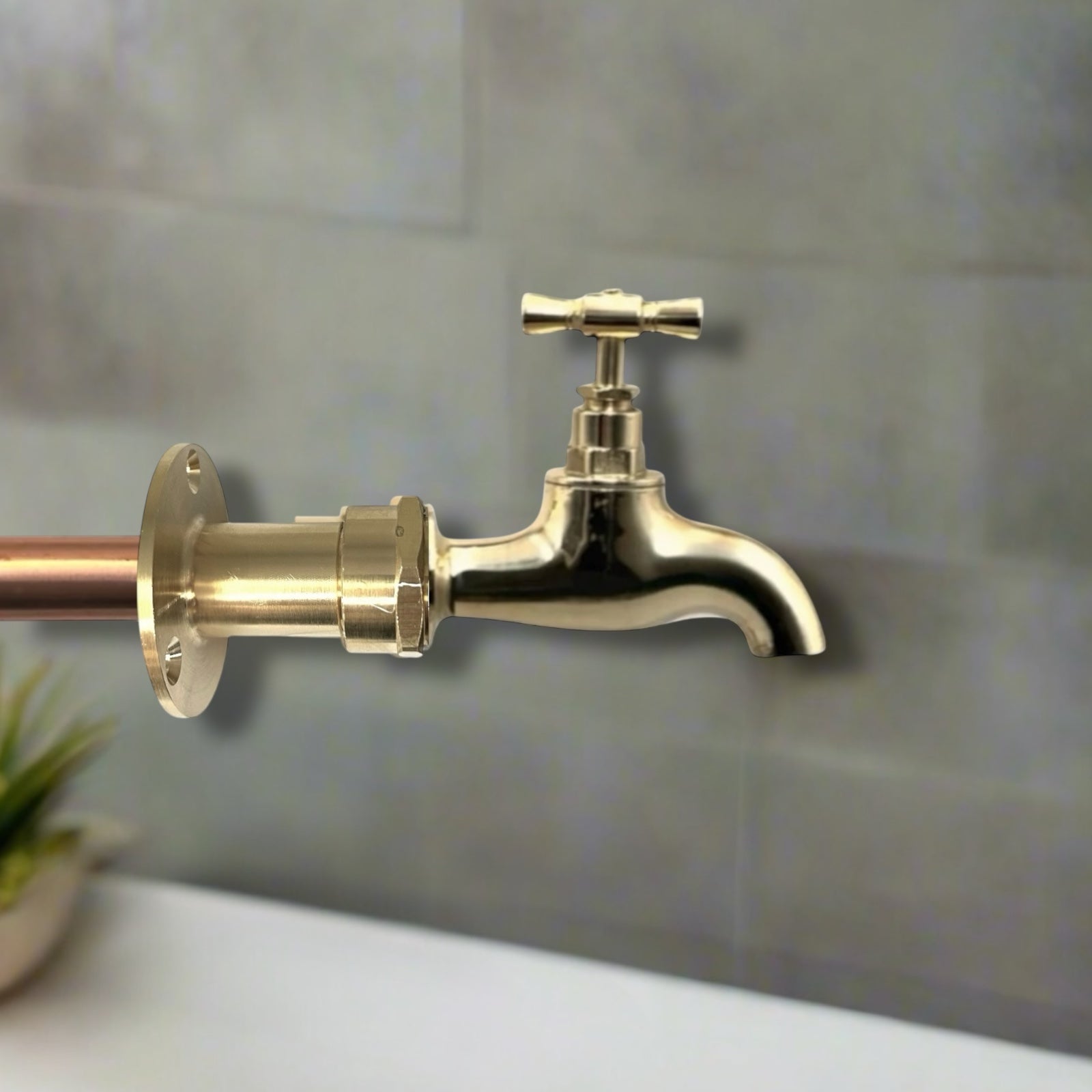 Brass faucet mounted on a tiled wall