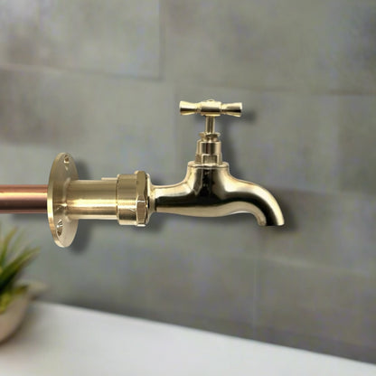 Brass faucet mounted on a tiled wall