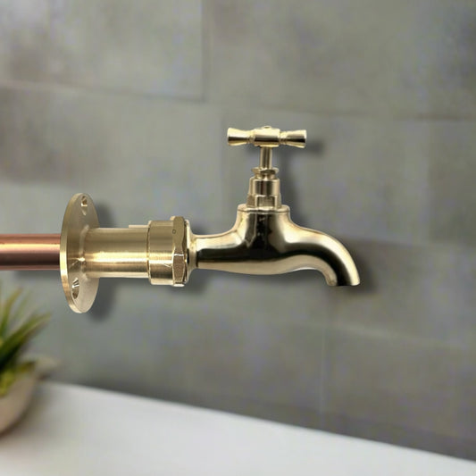 Brass faucet mounted on a tiled wall
