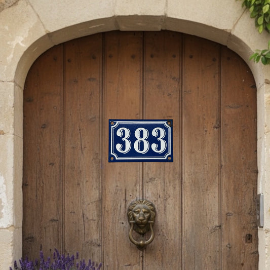 Wooden door with a blue and white number plate '383' and a lion knocker.