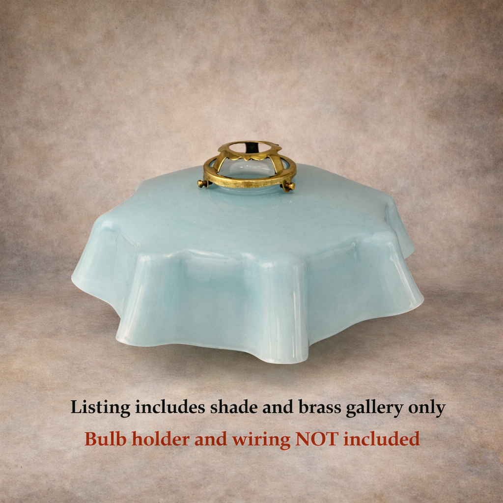 Light blue glass lamp shade with brass fitting on a beige background