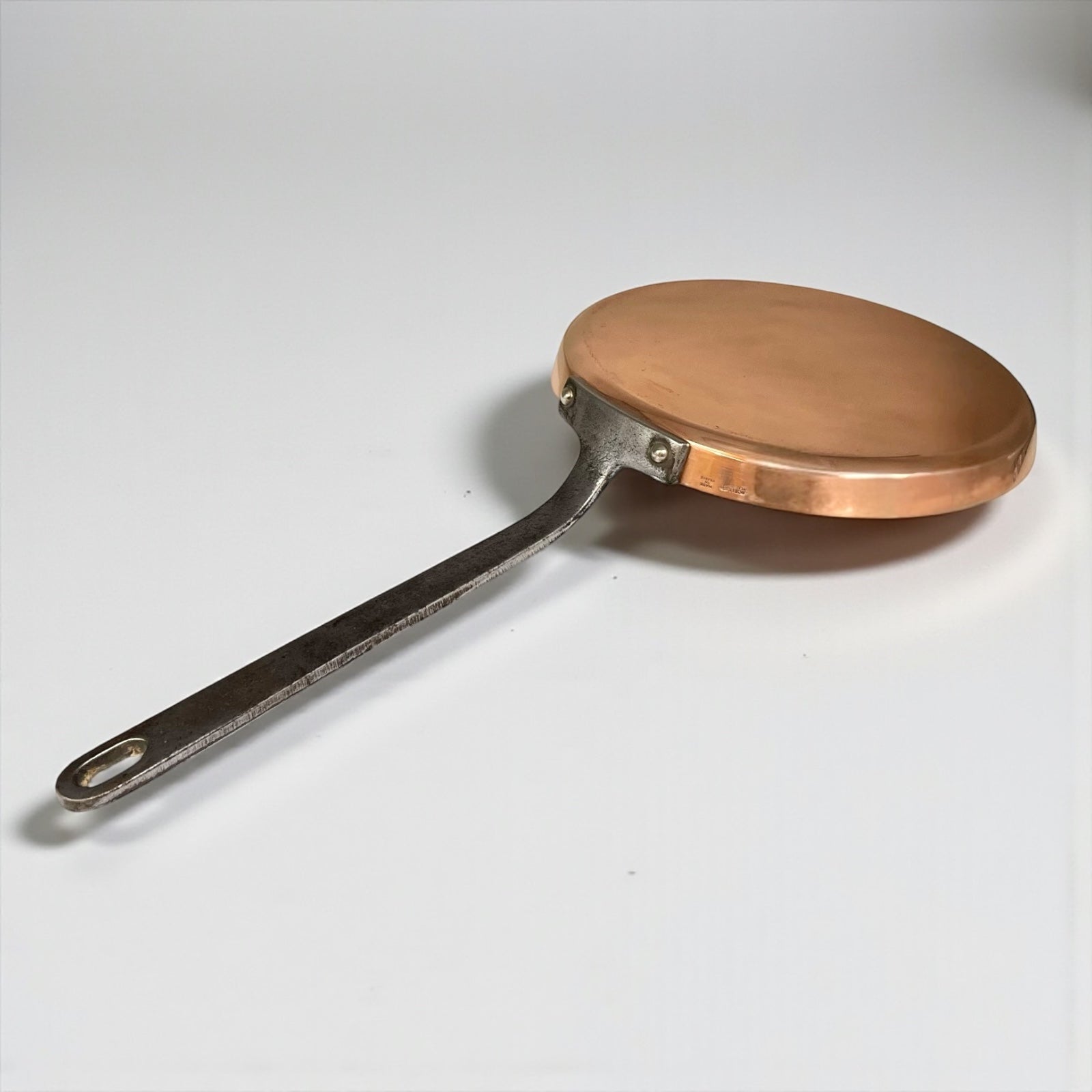 Copper frying pan with a silver handle on a white background