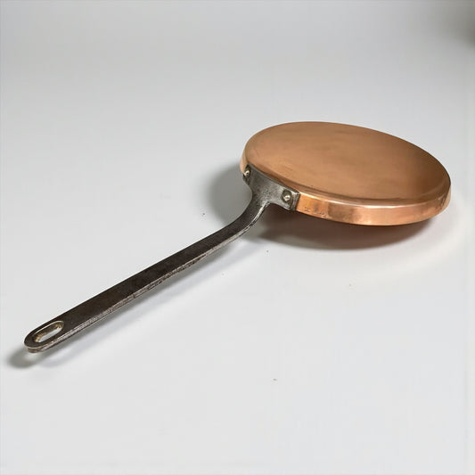 Copper frying pan with a silver handle on a white background