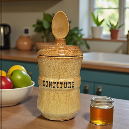 Ceramic confiture jar with a wooden spoon on a kitchen counter, next to a small jar of honey.
