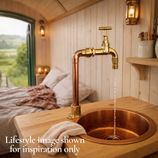 Copper sink with running water in a rustic cabin setting