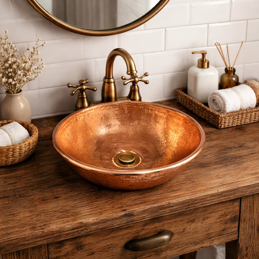 French copper cooking pot up cycled into a bathroom basin or camper van sink with a brass pop up wooden rustic vanity unit with a brass tap