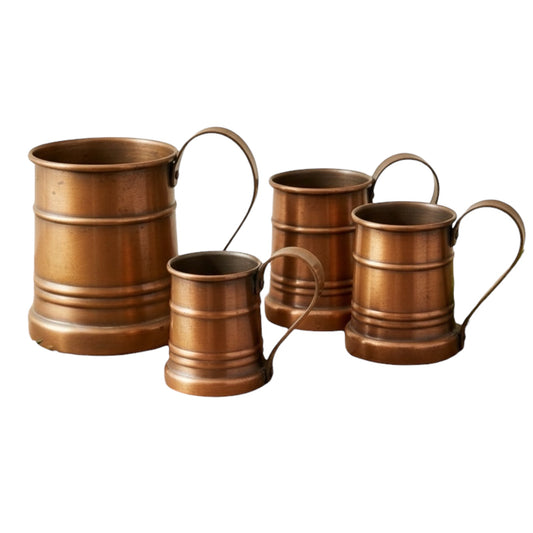 Set of four copper mugs with handles on a white background