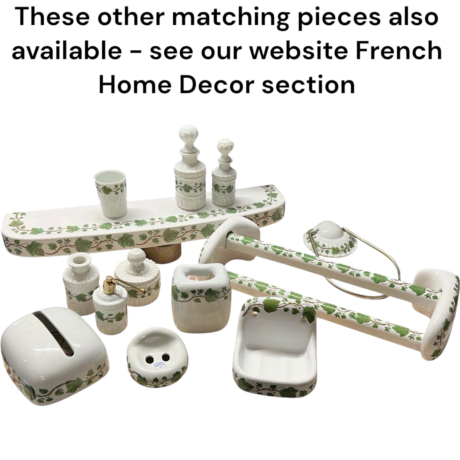 Set of porcelain bathroom items with green floral patterns on a white background.