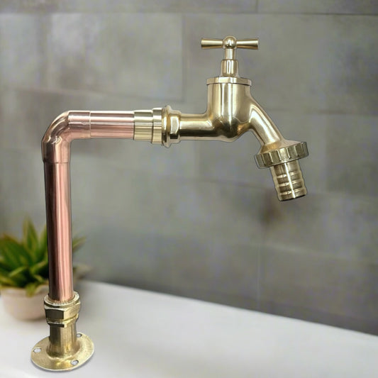 Brass and copper faucet on a tiled wall background