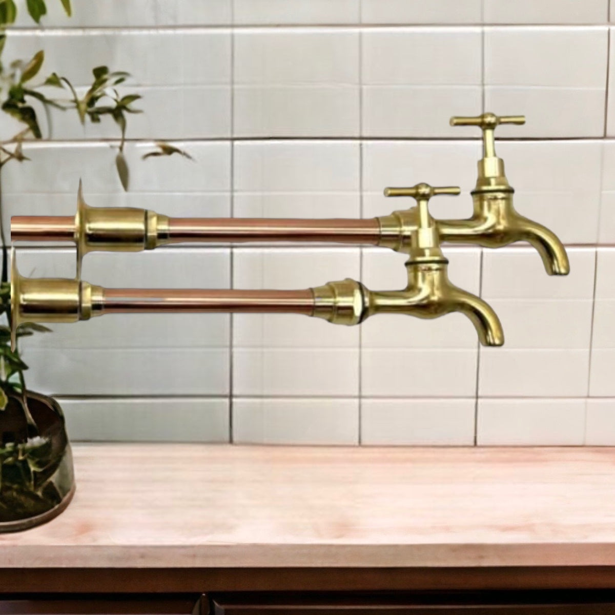 image pair of copper and brass wall mounted taps on a tiled background 