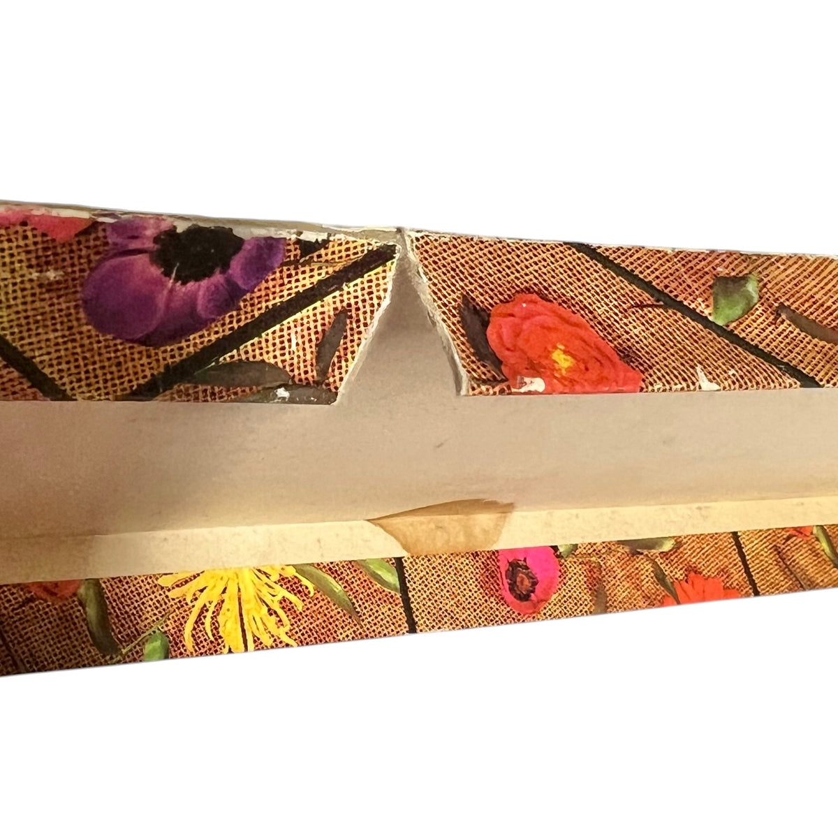 A close-up of a decorative retro box with a tear on a white background 