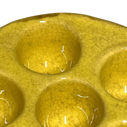 close up of a French vintage ceramic escargot serving plates, yellow inner with a brown exterior, each has 6 holes, shown on a white background 
