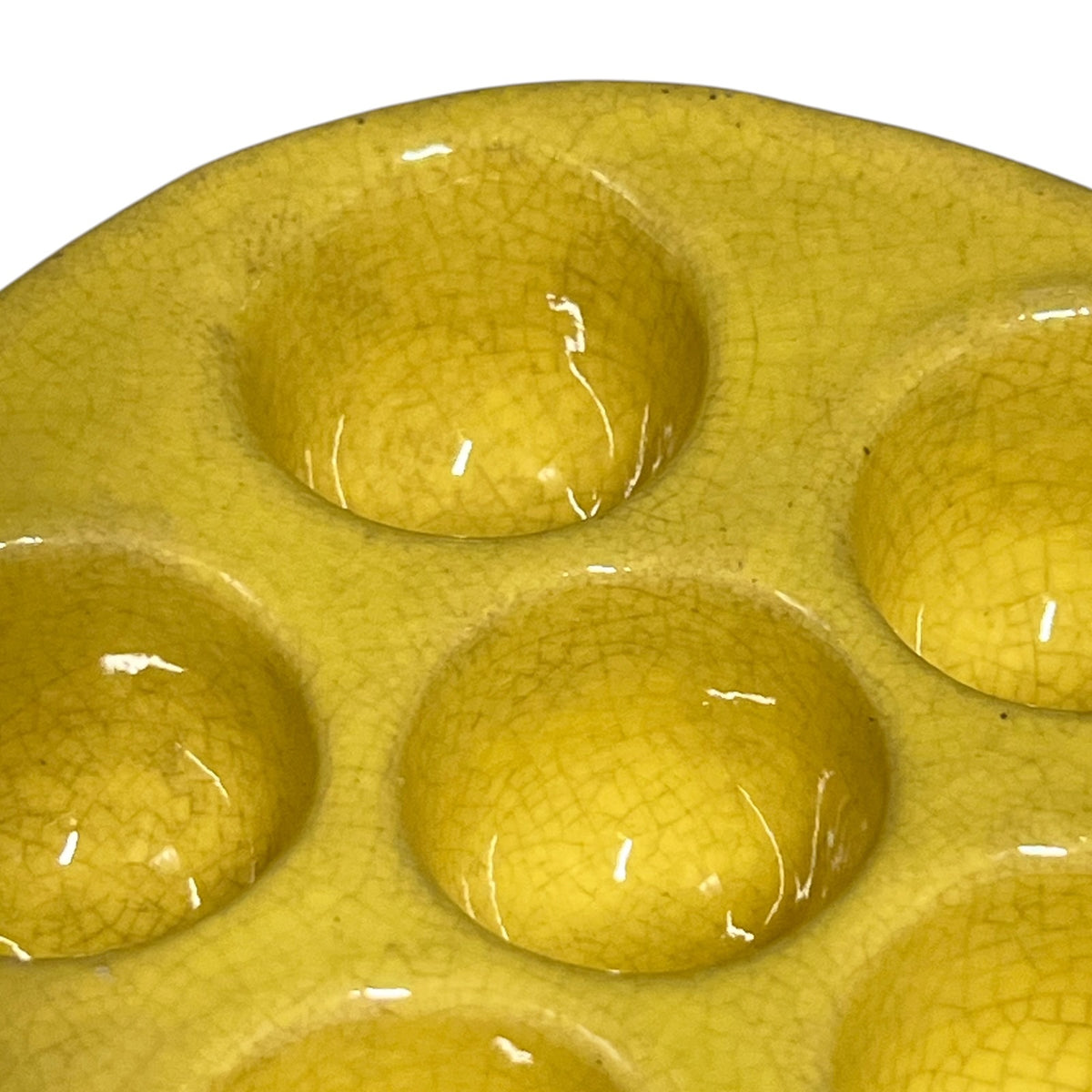 close up showing crackle glaze on a  French vintage ceramic escargot serving plates, yellow inner with a brown exterior, each has 6 holes, shown on a white background 