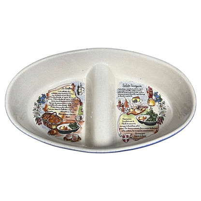 An oval ceramic divided serving platter with two compartments, featuring printed French food illustrations and recipe text on the inner surfaces.