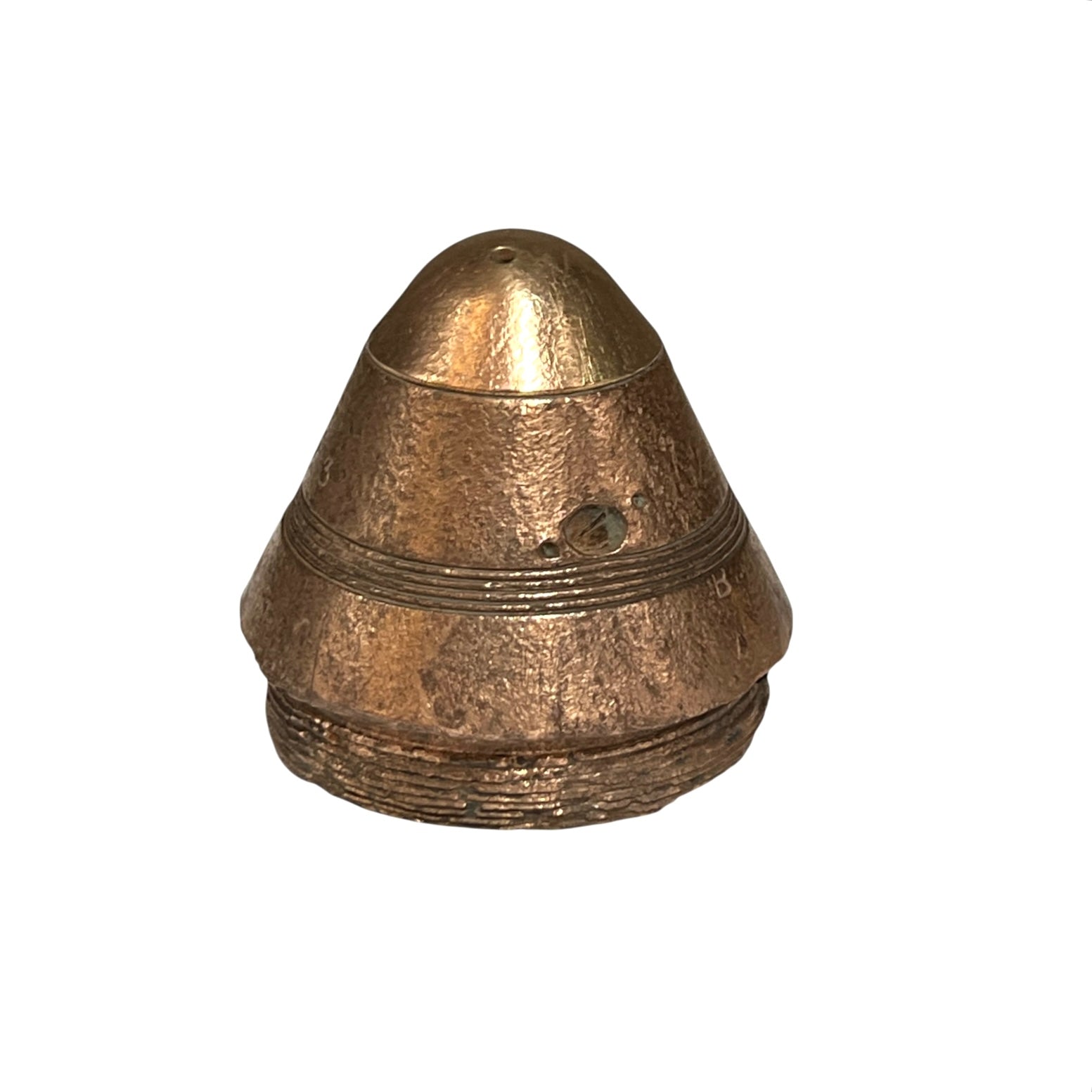 A small WW1 brass militaria fuse paperweight with a textured finish on a white background 
