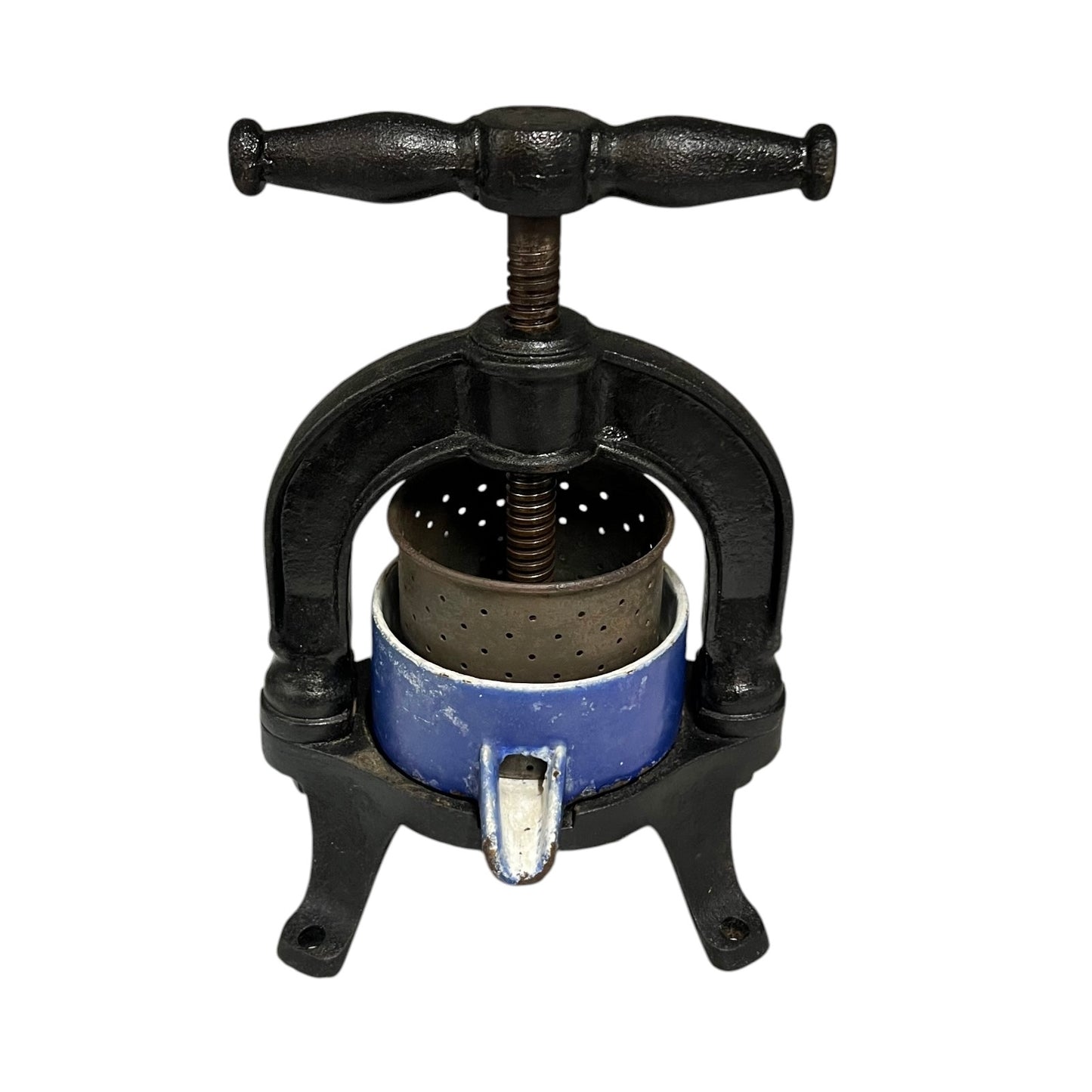 Black metal antique olive press with blue container on a white background