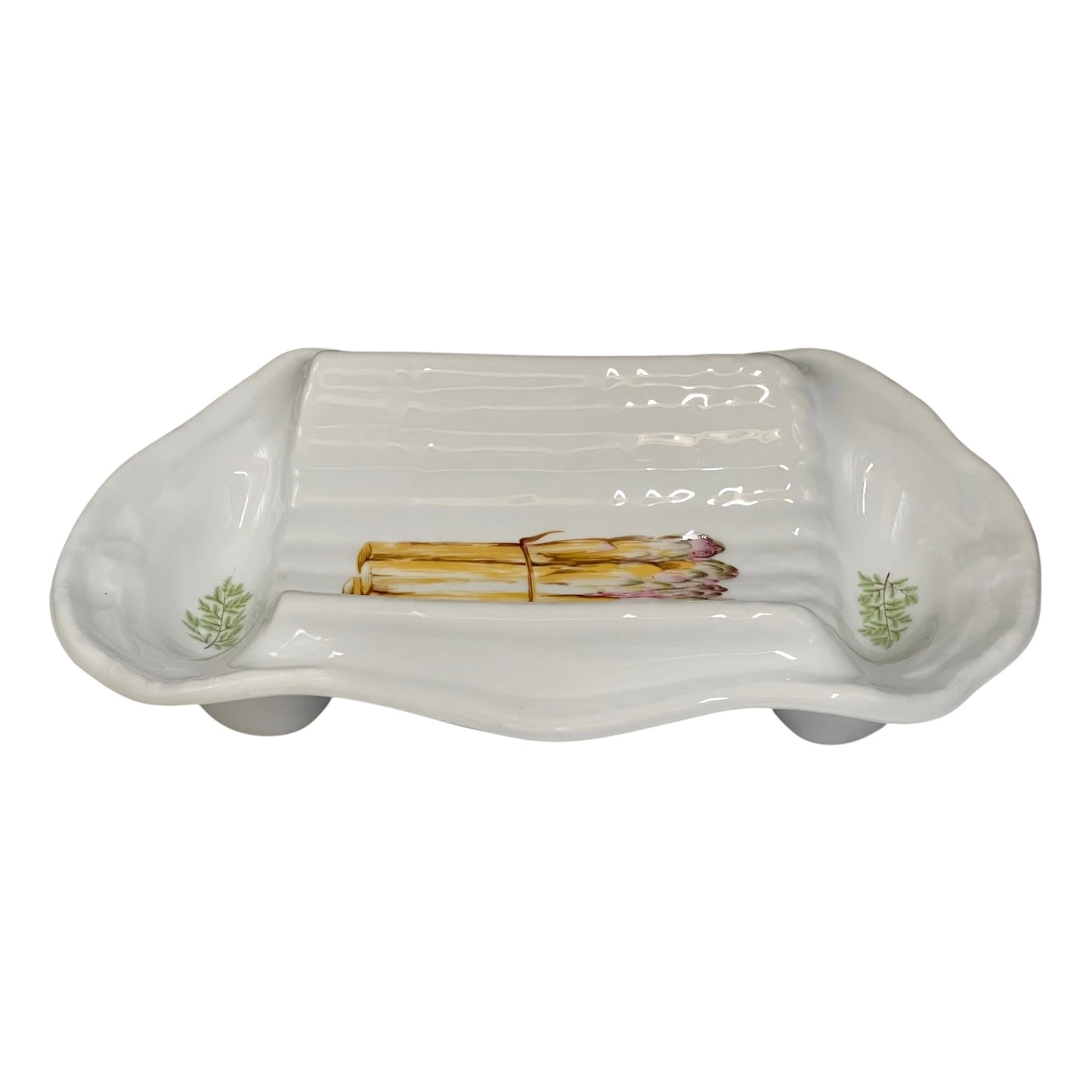 A white ceramic serving platter with a ribbed interior and asparagus illustrations near the corners, displayed on a white background