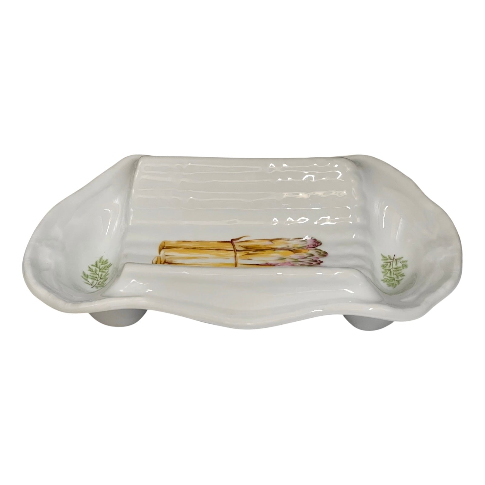 A white ceramic serving platter with a ribbed interior and asparagus illustrations near the corners, displayed on a white background