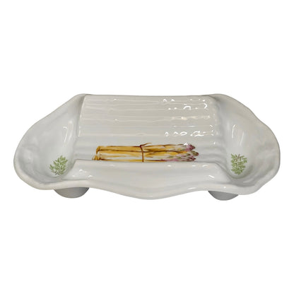 A white ceramic serving platter with a ribbed interior and asparagus illustrations near the corners, displayed on a white background