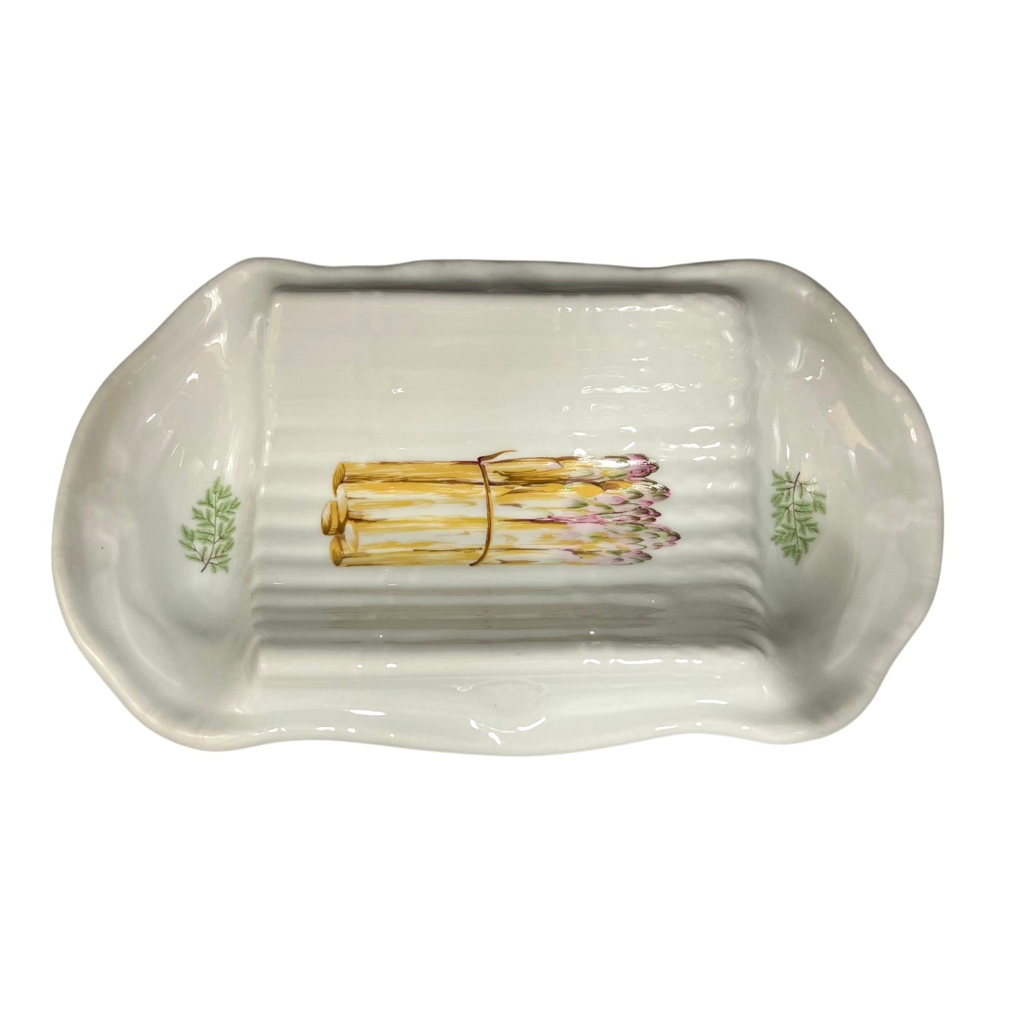 A white ceramic serving platter with a ribbed interior and asparagus illustrations near the corners, displayed on a plain white background