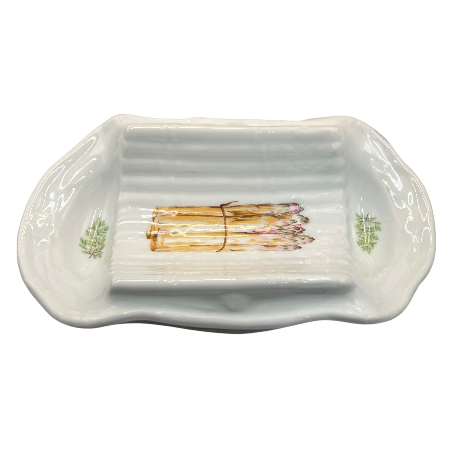 A white ceramic serving platter with a ribbed interior and asparagus illustrations near the corners, on a white background