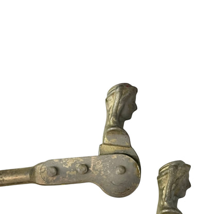 Close up of two rusty metal Belgian ladies shutter dogs on a white background