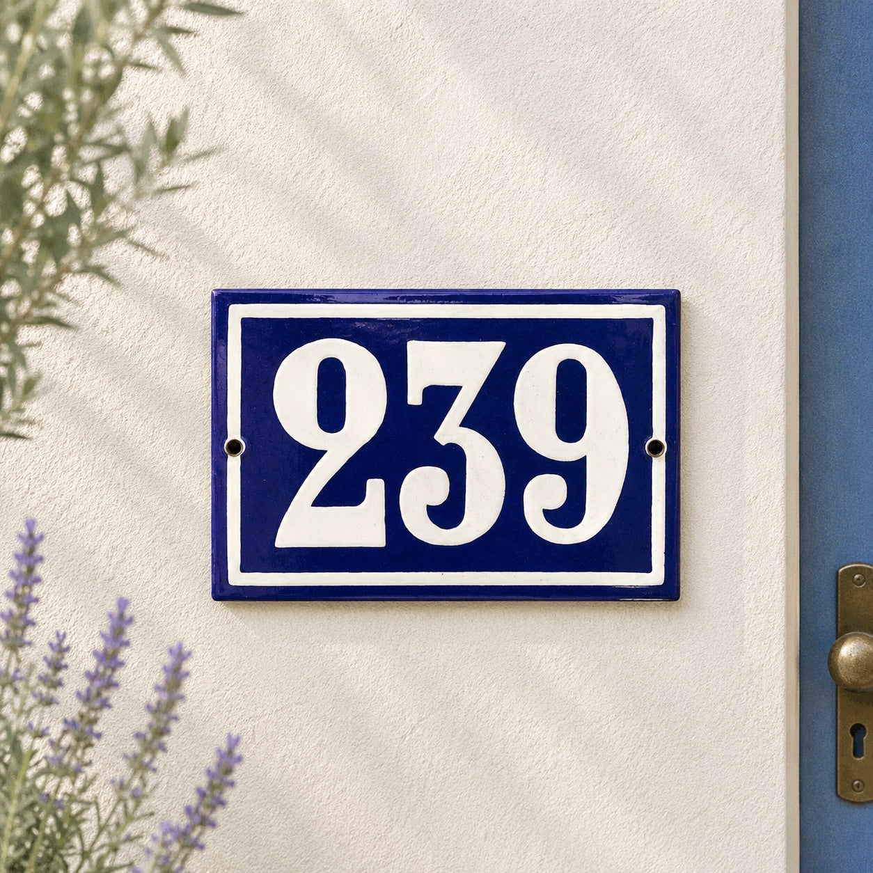 House number plate with '239' on a blue background attached to a white wall.