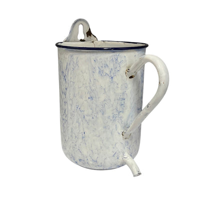 A vintage enamel pitcher with a white marbled pattern, a dark blue rim, a top carrying loop, and a side spout, shown on a plain white background.