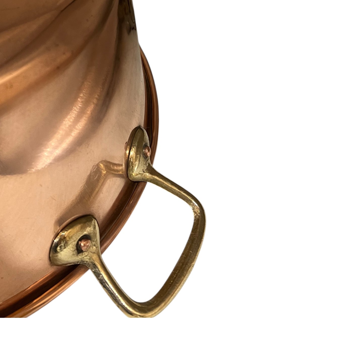 Close-up of a copper pot with brass handles on a white background