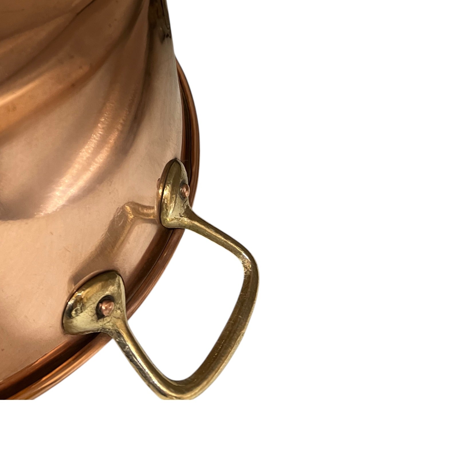 Close-up of a copper pot with brass handles on a white background