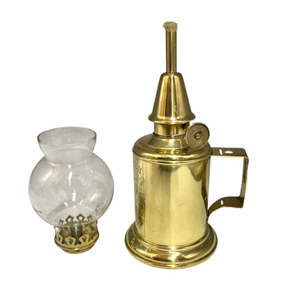 Brass oil lamp with clear glass reservoir on a white background