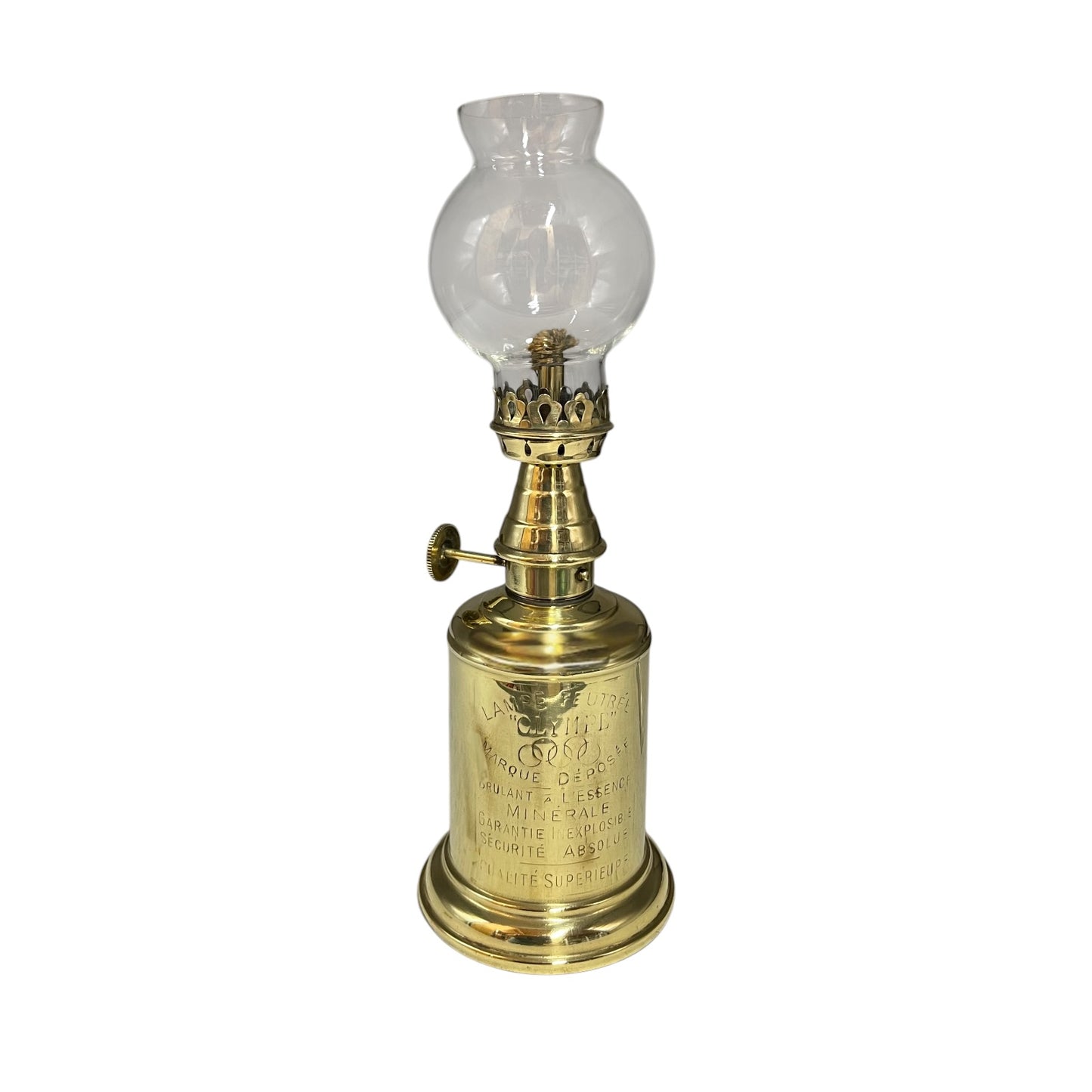 Brass oil lamp with clear glass shade on a white background
