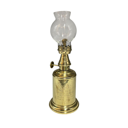 Brass oil lamp with clear glass shade on a white background