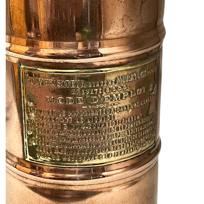 Copper and brass lamp with engraved text on a white background