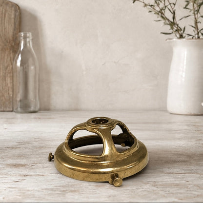 Brass vintage lampshade holder on a wooden surface with kitchen items in the background