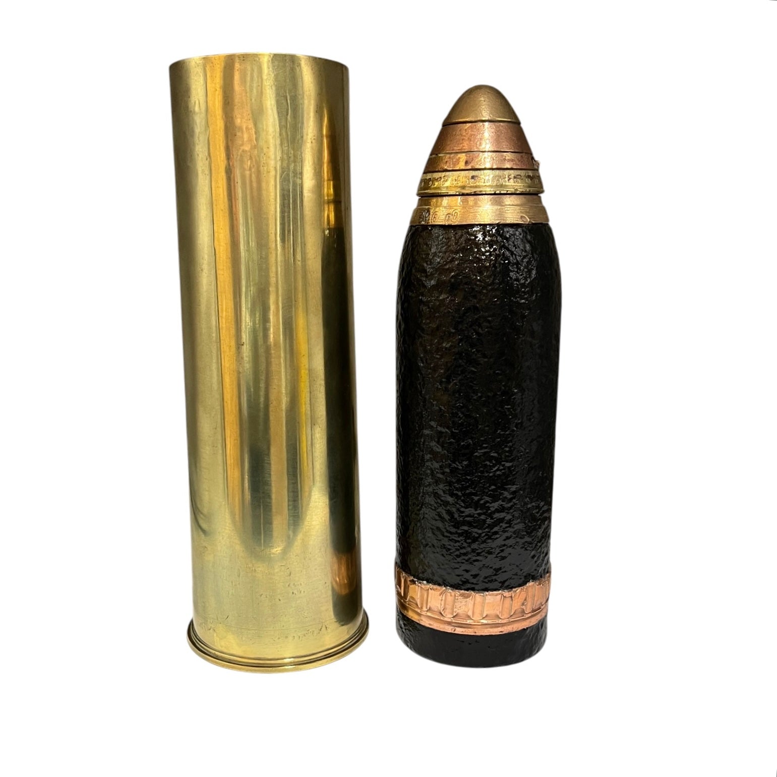 A decorative British WW1 18 pounder with a brass base, black mid section and brass fuse on the top, on a white background